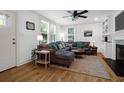 Comfortable living room featuring a large sectional couch, ceiling fan, hardwood floors, and bright windows at 1637 Pinckney Park Dr, Charleston, SC 29407
