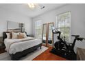 Bright bedroom with a king bed, two windows, and a mirrored closet with an exercise bike at 1726 Waterbrook Dr, Charleston, SC 29414