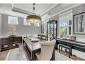 Elegant dining room with a large wooden table, decorative lighting, and ample natural light at 1814 Grovehurst Dr, Charleston, SC 29414
