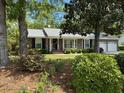 Charming brick home featuring a well-manicured front yard with mature trees and a two-car garage at 206 Brailsford Rd, Summerville, SC 29485