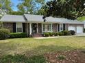 Charming brick home featuring a well-manicured front yard with lush landscaping and a two-car garage at 206 Brailsford Rd, Summerville, SC 29485