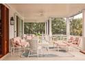 Covered outdoor porch with white wicker furniture and an outdoor ceiling fan at 2114 Pettigrew St, Sullivans Island, SC 29482
