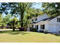 White two-story home with black shutters sits on a manicured lawn with mature trees adding shade at 212 Blue Heron Dr, Summerville, SC 29485
