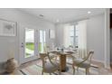 Cozy dining area with a round table, chairs, and bright natural light from the backyard door at 308 O'Malley Dr, Summerville, SC 29483