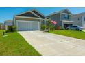 Residential street view featuring a neat lawn, attached garage and long driveway at 314 Bear Paw Ln, Summerville, SC 29486