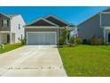 Inviting one-story home with a long driveway, attached garage and green lawn at 314 Bear Paw Ln, Summerville, SC 29486