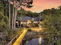 Stunning home featuring an outdoor deck, dock, and enchanting landscape lighting at 3610 Legareville Rd, Johns Island, SC 29455