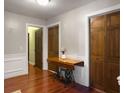 Hallway with warm wood floors, classic wainscoting, and vintage Singer sewing table at 411 Red Fox Run, Summerville, SC 29485