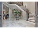 Elegant foyer with a curved staircase, marble floors, and decorative accents at 421 Royal Assembly Dr, Charleston, SC 29492
