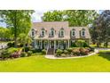 Beautiful home showcasing a well-manicured lawn, charming porch, and vibrant landscaping at 4403 Wild Thicket Ln, North Charleston, SC 29420