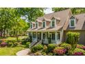 Inviting two-story home with a charming front porch and vibrant, well-maintained landscaping at 4403 Wild Thicket Ln, North Charleston, SC 29420