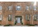 Beautiful brick facade with a central archway, a light blue door, and symmetrical flower boxes at 70 King St, Charleston, SC 29401