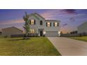 Beautiful home with a white exterior, a well-kept lawn, and a serene sunset backdrop at 715 Mcroy St, Moncks Corner, SC 29461