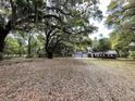 The two-story home features a sprawling yard with mature trees at 8392 Herbert Smalls Rd, Edisto Island, SC 29438