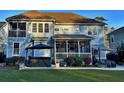 Back of light blue home featuring a spacious screened porch, a hot tub and a well-maintained yard at 855 Hunt Club Run, Charleston, SC 29414