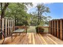 Inviting wooden deck with outdoor seating, offering serene views of the lush backyard and pond with fountain at 880 Simpkins St # 2, Charleston, SC 29412