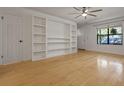 Bright living room featuring built-in shelving, hardwood floors, a modern ceiling fan and natural light at 880 Simpkins St # 2, Charleston, SC 29412