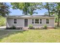 Attractive home showcasing a well-maintained lawn, gray siding, and a welcoming front entrance with a wreath at 105 Dalton Ave, North Charleston, SC 29420
