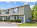 Townhouse with olive green siding and dark shutters complemented by lush green grass and tasteful landscaping at 1086 Lexi Ct, Ladson, SC 29456