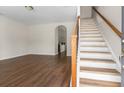 Open-concept living room features wood floors, staircase and an archway leading into the kitchen at 1086 Lexi Ct, Ladson, SC 29456