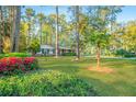 Quaint, brick home on a lush green lawn with mature trees and blooming bushes at 112 Furlong Rd, Summerville, SC 29483
