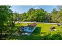 Exterior view of a one-story home surrounded by greenery, featuring a lush lawn and street view at 11341 Cottageville Hwy, Cottageville, SC 29435
