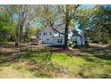 Spacious backyard with manicured lawn, mature trees and a black metal fence around the perimeter at 12 Trail Hollow Ct, Charleston, SC 29414