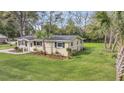 A home showcasing its lawn and the side, featuring a mature palm and fenced yard at 1239 Old Orchard Rd, Charleston, SC 29412
