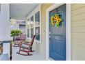 Cozy front porch with rocking chairs and a decorative sunflower wreath on the front door at 132 Daniels Ridge Dr, Summerville, SC 29485