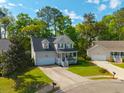 Aerial view of a two-story home with a front porch, garage, and landscaped yard in a suburban neighborhood at 133 Hanahan Plantation Cir, Hanahan, SC 29410
