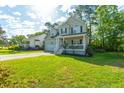 Beautiful two-story home features a welcoming front porch, lush green lawn, and inviting curb appeal at 133 Hanahan Plantation Cir, Hanahan, SC 29410