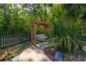 Charming backyard swing beneath a wooden pergola, surrounded by lush greenery and a peaceful setting at 1440 Teaberry Path, Charleston, SC 29414