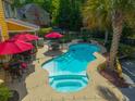Aerial view of a pristine backyard pool featuring a spa, outdoor dining, and plenty of space at 1440 Teaberry Path, Charleston, SC 29414