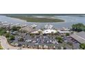 This aerial view features a large parking lot, commercial buildings, and docked boats at the marina at 1880 Andell Bluff Blvd # Slip E 9, Johns Island, SC 29455
