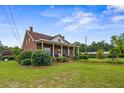 Well-maintained home features a spacious lawn, charming front porch, and mature trees at 200 Broughton Rd, Moncks Corner, SC 29461