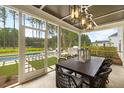 A charming outdoor patio featuring a dining table and view of a beautiful backyard with a pool at 208 Quimby Hill Dr, Huger, SC 29450