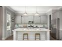Beautiful kitchen features gray cabinets, stainless steel appliances, a white island, and hardwood floors, creating a modern feel at 320 Archar St, Summerville, SC 29486