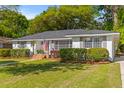 Inviting single-story home with a brick exterior, lush landscaping, and a well-maintained lawn at 405 Cross St, Charleston, SC 29407