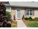 Welcoming front entrance with brick facade, blue door, green bushes, and charming decorations on a sunny day at 422 Temple Rd, Ladson, SC 29456