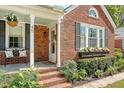 Inviting brick front porch with white columns and black shutters at 45 Lyttleton Ave, Charleston, SC 29407