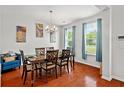 An inviting dining room with natural light, hardwood floors, and elegant chandelier at 514 Morelets Dr, Moncks Corner, SC 29461