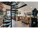 A luxurious open-concept kitchen showcasing a spiral staircase, stainless steel appliances and bar seating at 517 King St # 1, Charleston, SC 29403