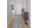 Bright hallway featuring hardwood floors, a stylish console table, modern mirror, and natural light from a window at 596 Red Monarch Way, Moncks Corner, SC 29461