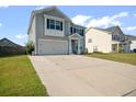 Two-story home featuring light gray siding, black shutters, a two-car garage and paved driveway at 613 Ravens Wood Rd, Summerville, SC 29486