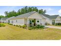 Well-manicured lawn complements this charming single-story home with a welcoming front porch in a peaceful neighborhood at 1003 Locals St, Summerville, SC 29485