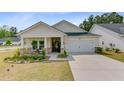 Charming single-story home boasts a manicured lawn and inviting front porch, complete with stone accents at 1003 Locals St, Summerville, SC 29485