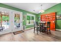 Bright dining area featuring green walls, wood floors, and natural light from French doors and a large window at 1016 Providence Way, Summerville, SC 29483