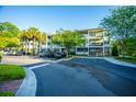 Exterior of a multi-story building with well-maintained landscaping and ample parking spaces at 1025 Riverland Woods Pl # 1023, Charleston, SC 29412