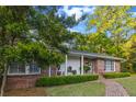 Beautiful brick home with a covered front porch, brick sidewalk, trimmed hedges, and mature landscaping at 114 California Ave, Moncks Corner, SC 29461