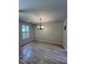 Bright dining room with hardwood floors, a modern chandelier, and ample natural light from the large window at 1220 Apex Ln, Charleston, SC 29412